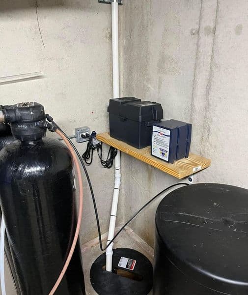 Water filtration system with storage containers and plumbing in a basement setting.