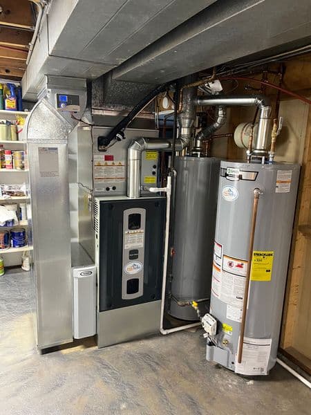 Modern HVAC system with furnace and water heater in a basement setting. Efficient and compact.